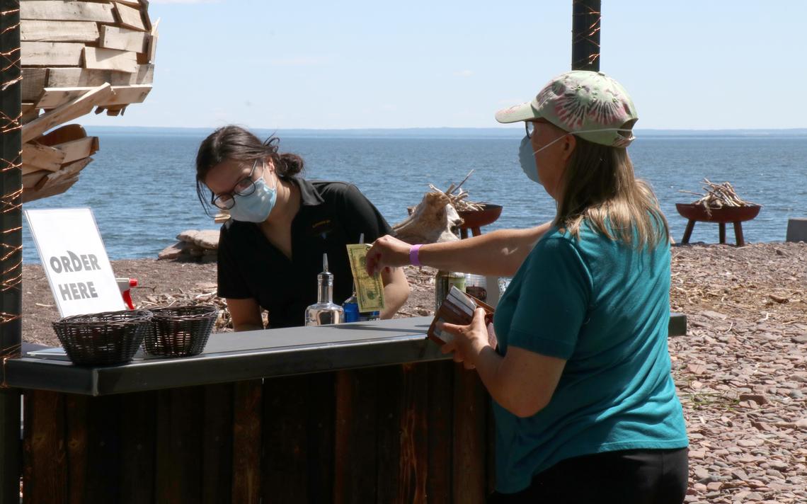Eileen Rathbun, of Anoka, Minnesota, purchases a beverage at Glensheen's new outdoor bar. Bellisio's Catering is hosting the bar, which offers local beer, wine, cocktails and non-alcoholic beverages. Local ice cream from Love Creamery is also offered at the estate's Lake Superior shoreline. (Samantha Erkkila / serkkila@duluthnews.com)