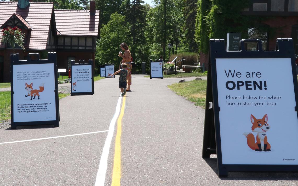 A family follows the signage and yellow and white lines to Glensheen's carriage house to purchase tickets for self-guided tours on Thursday afternoon. (Samantha Erkkila / serkkila@duluthnews.com)