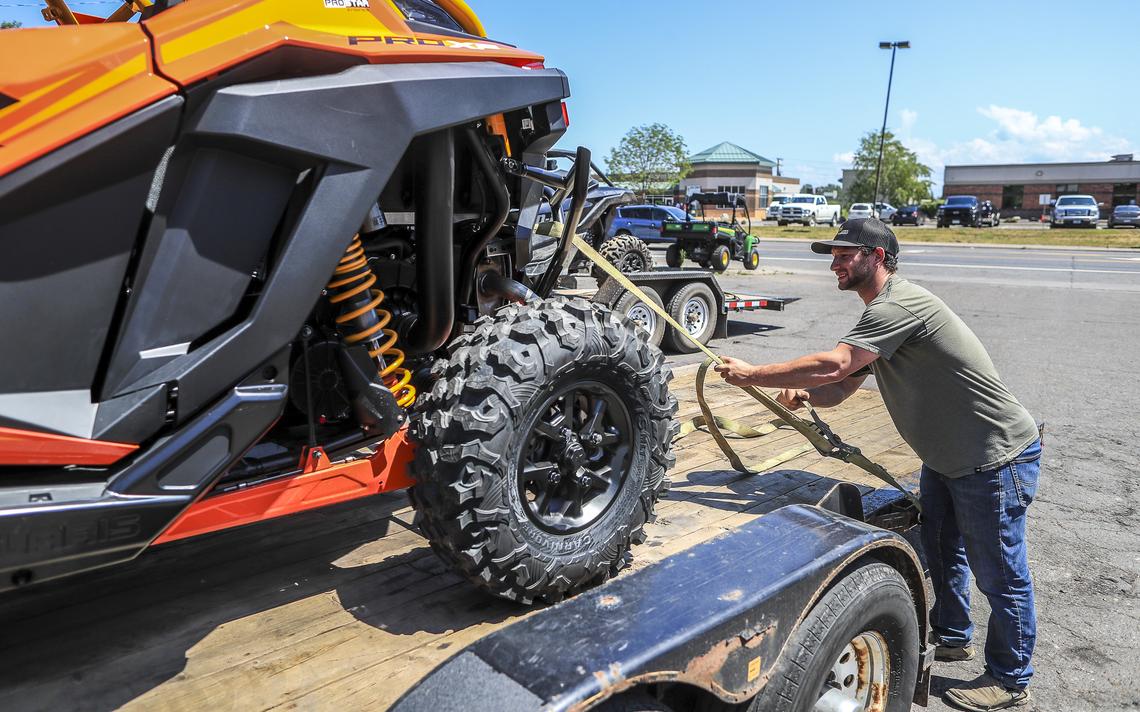 Duluth Lawn & Sport employee Chris Gassert of Moose Lake ties down a Polaris RZR Pro XP side-by-side ATV Thursday on a trailer before to delivering the vehicle to a customer in Two Harbors. (Clint Austin / caustin@duluthnews.com) 