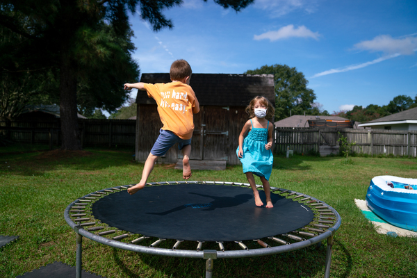 Lachlan (left) and Lillian Barilleau play in the backyard of their home in Central, La. They were displaced from the house for months after a flood in 2016.