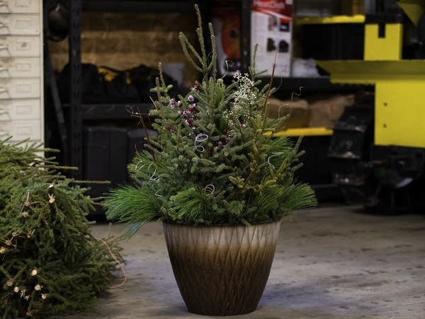 An arrangement of greenery and sparkling decorations in a pot.