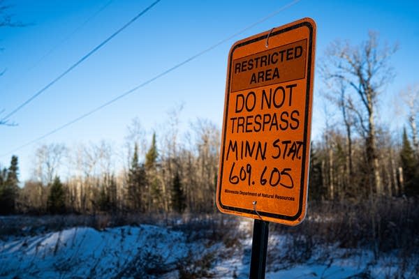 An orange sign warns trespassers.