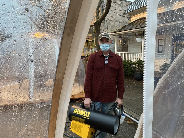 Tim Baker, owner of the Seattle restaurant San Fermo, holds the hot air cannon he uses inside the dining 'igloos' ahead of each seating. After a thorough ventilation, the device warms up the interior, he says, and also helps disperse any lingering infectious particles.