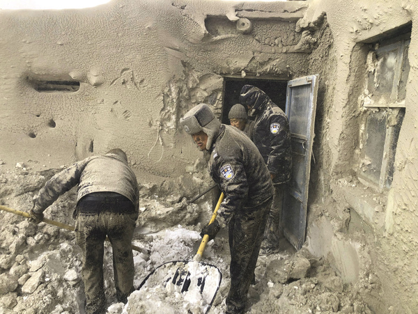 Policemen work to dig out a 71-year-old woman whose house was besieged by a snow- and sandstorm in China's Inner Mongolia on March 15 of this year.
