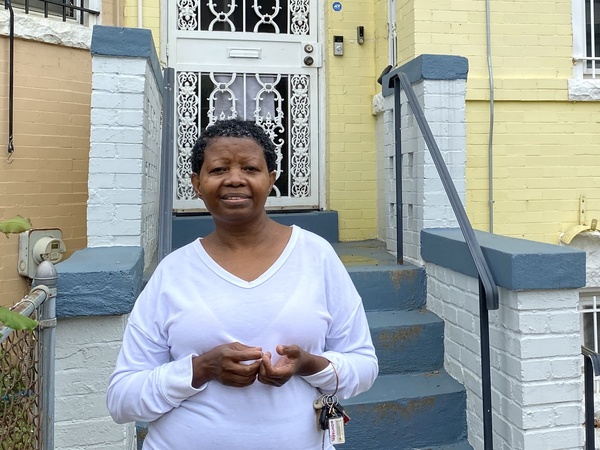 Katherine Gaines stands in front of her childhood home in Washington, D.C. She moved back in two years ago to help care for her mother, who has Alzheimer's disease.