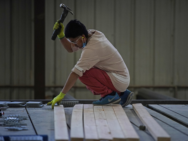 A worker in Spanish Fork, Utah, assembles a truss for a home on May 12. The surge in lumber prices was seen by some economists as another example of potentially rampant inflation. Instead, prices fell.