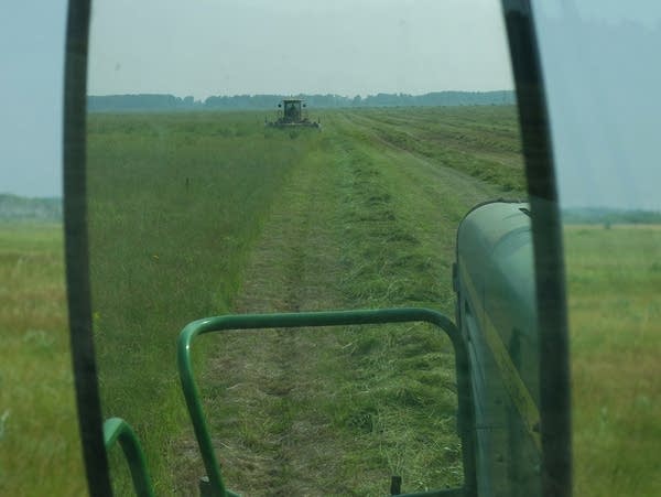 a machine cuts grass in a field 