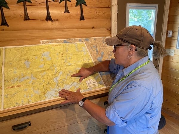 A person points to an area on a large map.
