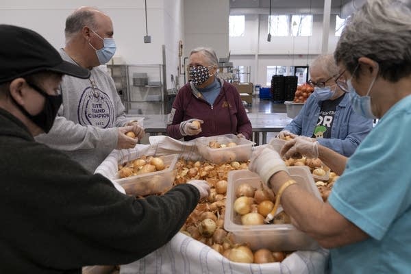 People work to pack food at a food shelf