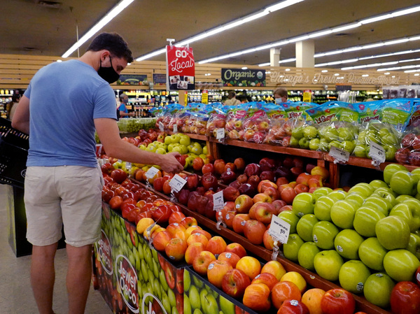Customers shop for produce at a supermarket on June 10 in Chicago. Inflation has surged to a 30-year high as consumers have gone on a shopping spree, leading to a widespread shortage of goods.
