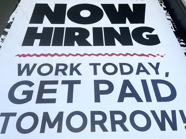 A "Now Hiring" sign is displayed at a fast food chain on June 23 in Los Angeles. Businesses are eager to hire, but they are struggling to find workers because of a number of factors, including difficulties in finding child care or fears about getting infected with COVID-19.