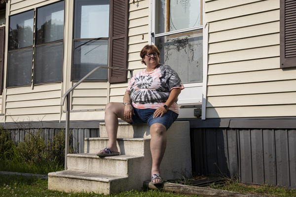 Mary Hunt, poses for a portrait outside her home in Swartz Creek, Mich., on Aug. 4. Hunt makes $10 an hour driving people to doctors appointments. She has faced eviction from her manufactured home park.