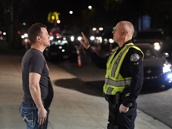 A man undergoes a sobriety test at a LAPD police DUI checkpoint in Reseda, Los Angeles, on April 13, 2018. A new federal law will eventually require new vehicles to detect and prevent drunk driving, which would revolutionize vehicle safety.