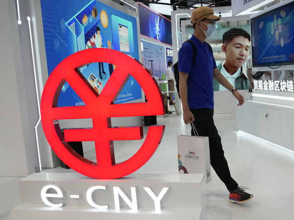 A visitor passes by a logo for the e-CNY, a digital version of the Chinese Yuan, displayed during a trade fair in Beijing, China, on Sept. 5, 2021. China is among a handful of countries that are experimenting with national digital currencies.