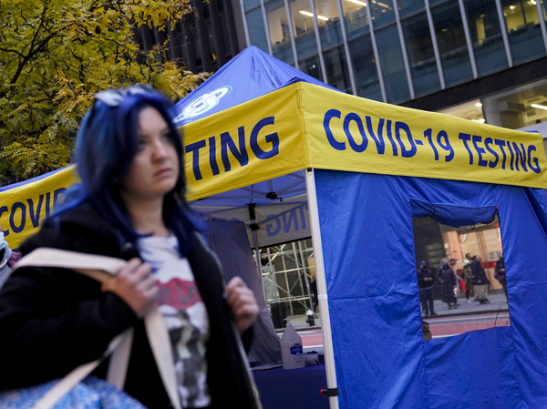 Pedestrians pass a COVID-19 testing tent in New York City, N.Y., on Dec. 2, 2021. Omicron-related coronavirus infections appear to be declining.