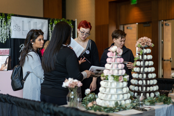 Ashley Lydon (center), checking out macaroon options at the Mariela's Sweets booth during the Great Bridal Expo in Boston, says after two years of pandemic restrictions, she's planning a wedding that will be "over the top."  She came with Cheryl Carey, (right) her matron of honor, and Hannah Lydon, her maid of honor (left).