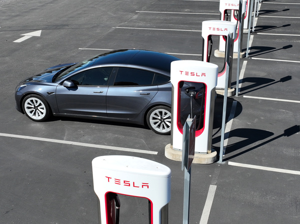 A Tesla car recharges at the Tesla Supercharger station in Petaluma, Calif., on March 9. Prices of used Teslas have surged because of a lack of new cars.