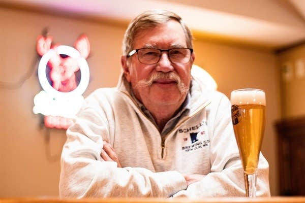 Man looks at camera with glass of beer