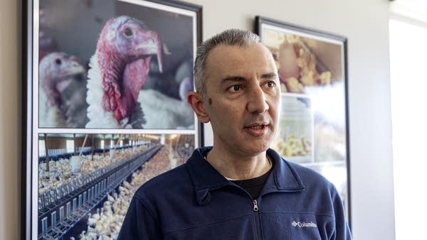 Man speaks next to photos of birds