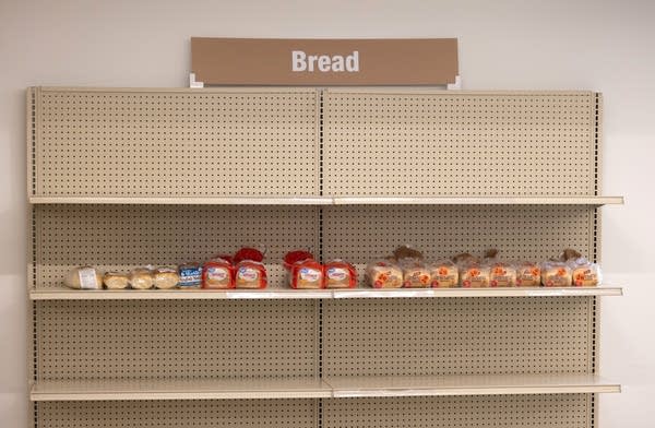A food shelf with many shelves with no food on it.