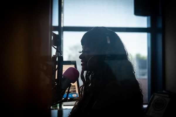 A person speaks into a microphone at a radio station
