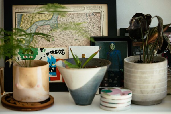 A photo of Stickler as Elphaba in Wicked sits next to a framed map of New York City in Stickler's home in Chicago. Now a software engineer, Stickler previously worked as a Broadway performer.