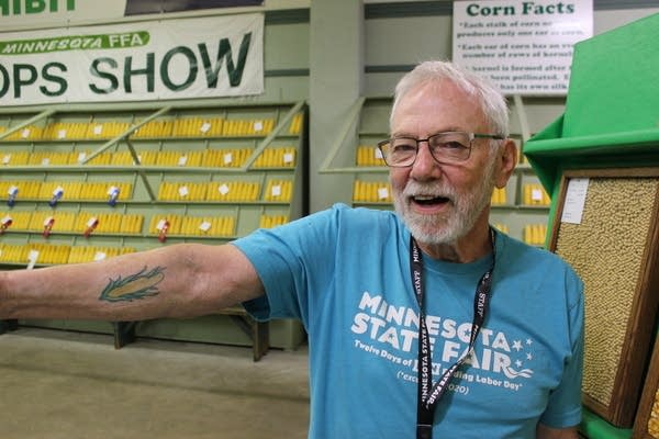 A man shows a tattoo on his arm of corn cob