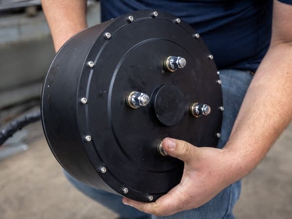 A person holds a heavy electric motor