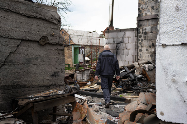A Ukrainian resident of Moschun walks through the remains of his home in Moschun, a Kyiv suburb, in April.