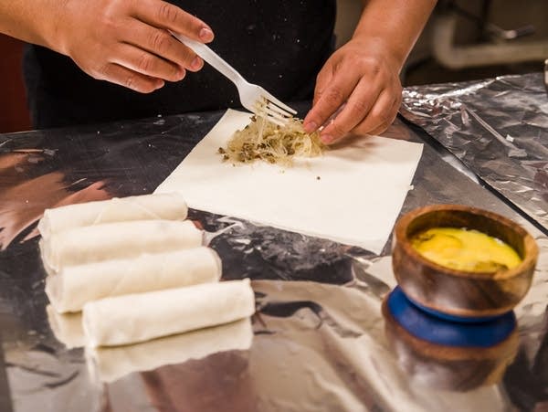 Dao See prepares egg rolls to sell at Rochester's Night Market