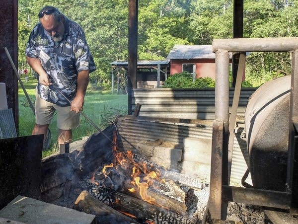 Frank Bibeau tends the fire at the small wild rice processing plant 