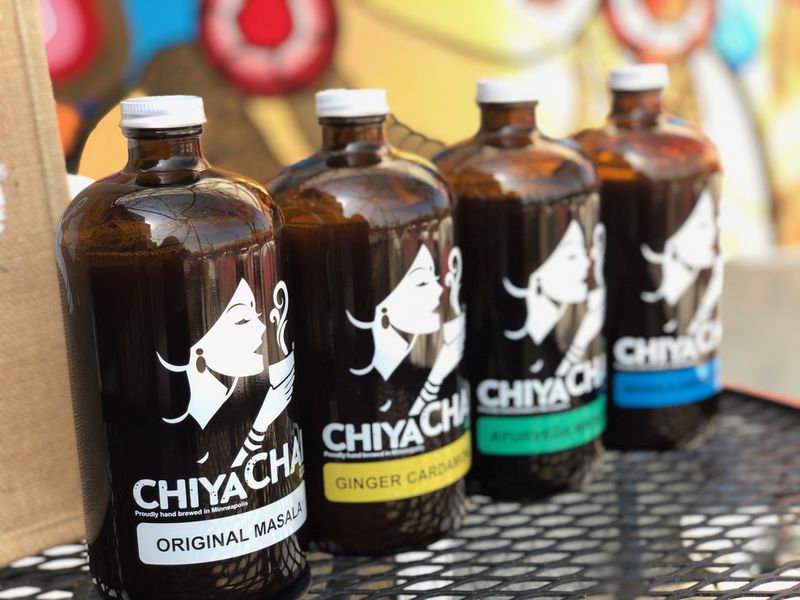Four brown growlers with white labels reading “Chiya Chai” on a table. 