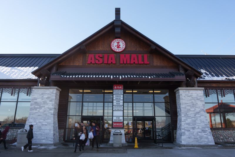 The exterior of Asia Mall: two brick pillars flank glass doors and windows, and a large crowing archway reads “Asia Mall.”
