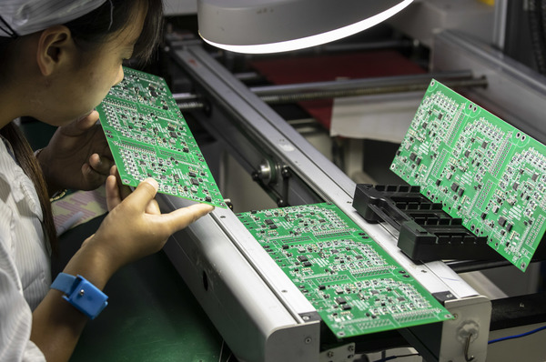 An employee inspects integrated circuit boards at the Smart Pioneer Electronics Co. factory in Suzhou, China, on Sept. 23.