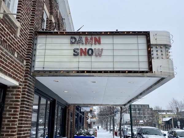 The theater sign reads "Damn Snow."