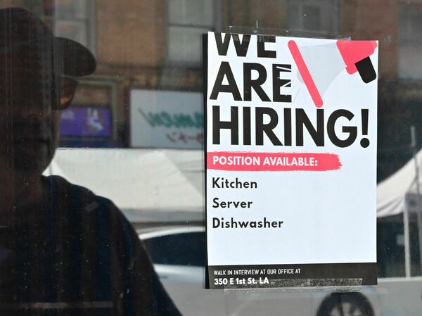 A "We Are Hiring" sign is posted in front of a restaurant in Los Angeles on Aug. 17, 2022. The labor market remains resilient, raising hopes that any recession would be mild.
