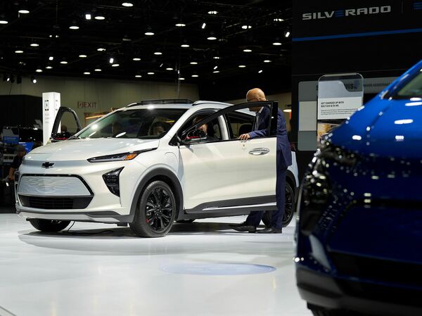 A man looks inside a Chevy Bolt EUV at the North American International Auto Show in Detroit, Michigan on Sept. 14, 2022. Automakers are pouring billions of dollars to develop electric cars.