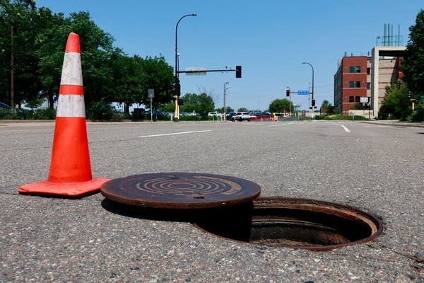 A manhole cover open on a street.