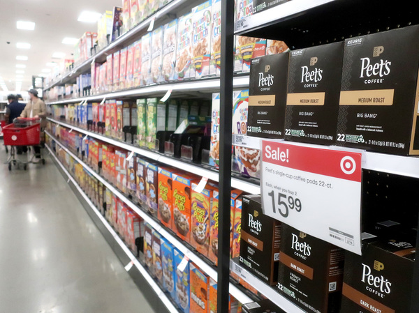 People shop at a Target store in Los Angeles where a sale sign is displayed for coffee pods on Feb. 13, 2023. Inflation has been easing since peaking last year, but it's still sturdier than many economists had expected.