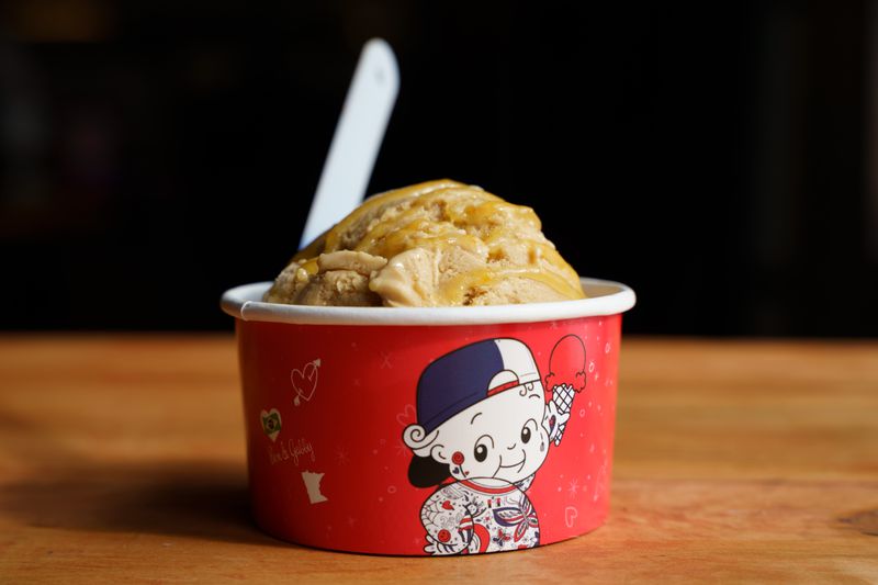 A red paper cup filled with toffee-colored ice cream. 
