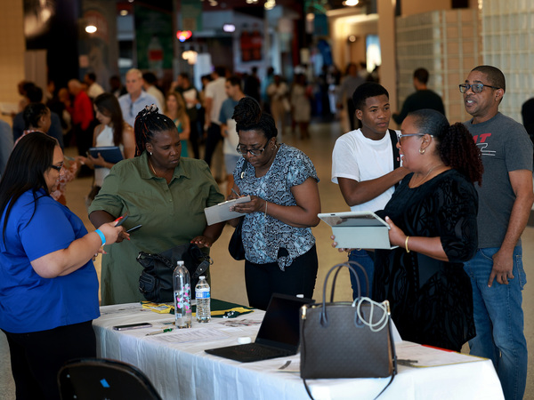 Job seekers fill out forms at the Jamaican Restaurant booth at the Mega South Florida Job Fair held in the FLA Live arena in Sunrise, Fl., on Feb. 23, 2023. Leisure and hospitality are among the sectors that are in need of workers.