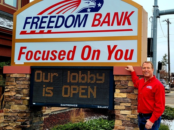 Don Bennett, the founder and CEO of Freedom Bank in Columbia Falls, Montana, stands in front of his lender. Bennett founded the bank in his basement and has expanded it over the years.