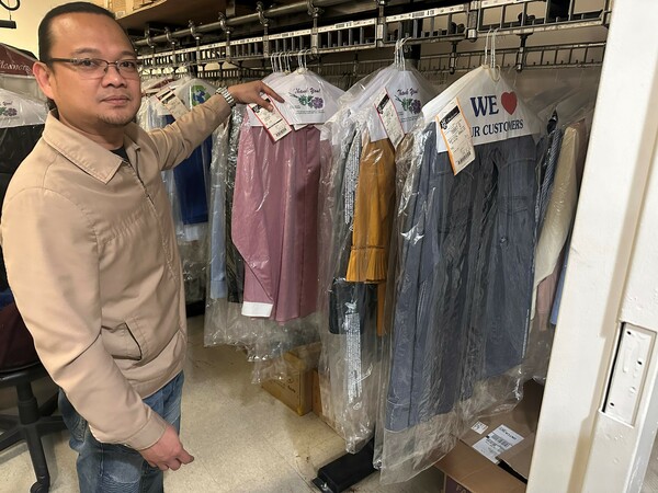 Dry cleaner Mart Mandingo shows clothes that were dropped off just days before the pandemic and never picked up.