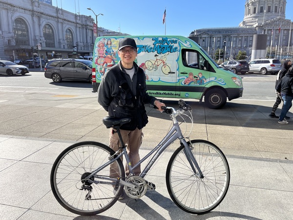 San Francisco resident Daniel Leong poses with a bike be brought to a San Francisco Public Library repair day
