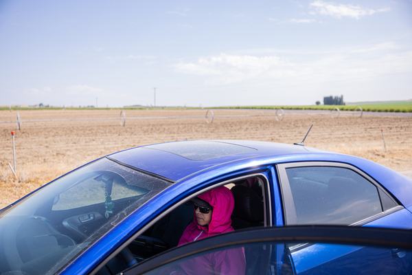 Farmworker Patricia Mendoza sits in her car next to a watermelon field in Eltopia, Wash., on June 26, 2023.