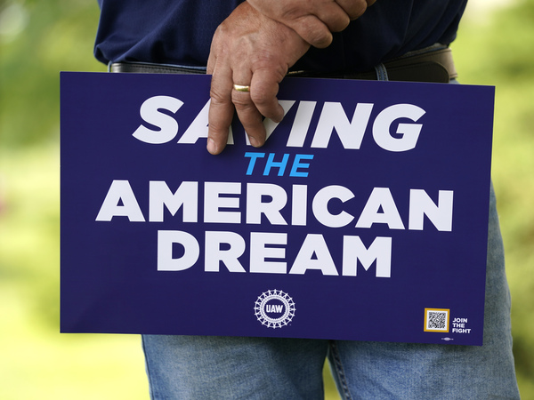 United Auto Workers member holds a sign outside the General Motors Factory Zero plant in Hamtramck, Mich., on July 12.