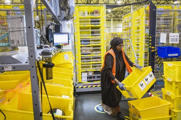 An Amazon warehouse employee carries