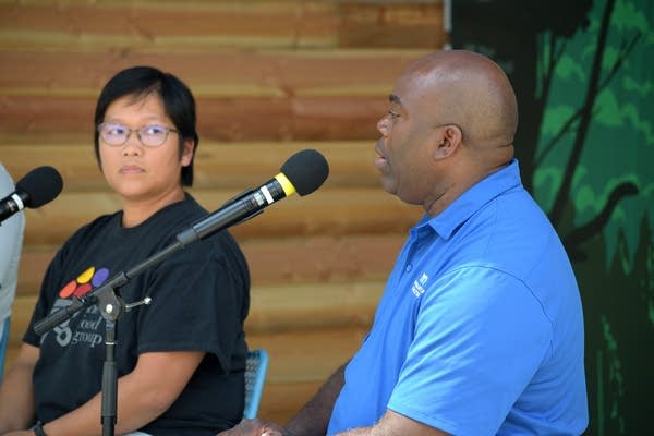 two people speak on a microphone
