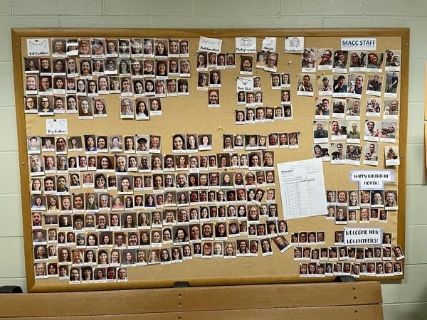 A bulletin board displays photos of people