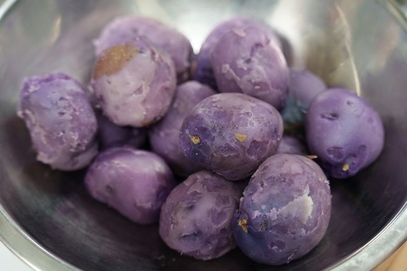 A bowl of peeled purple potatoes.